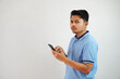 © DMH - expression of dislike trying to dodge with holding phone young asian man wearing blue polo t shirt isolated on white background