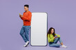 © ViDi Studio - Full body young couple two friends family man woman wear casual clothes together sit big huge blank screen mobile cell phone with area use smartphone isolated on pastel plain light purple background.