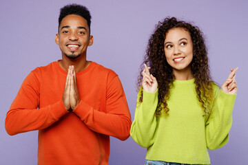 Sticker - Young couple two friends family man woman of African American ethnicity wear casual clothes together wait special moment, keeping fingers crossed pray isolated on pastel plain light purple background.