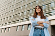 © EFStock - Portrait confident young woman standing in the city looking to the side with happy expression