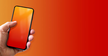 Hand holding a smartphone with blank red and orange screen. Colorful horizontal banner.