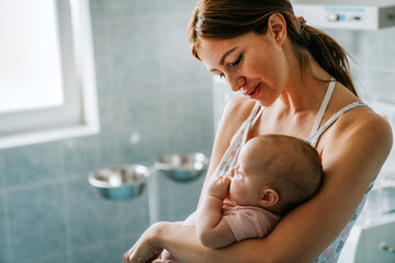 Portrait of beautiful mother with her baby in the hospital background