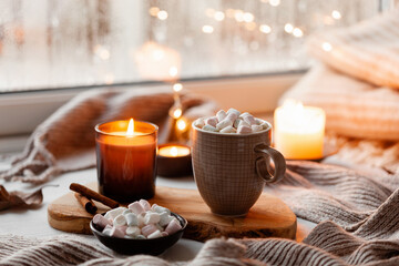 Wall Mural - warm cozy window arrangement, winter or autumn concept, coffe, candles throw lights