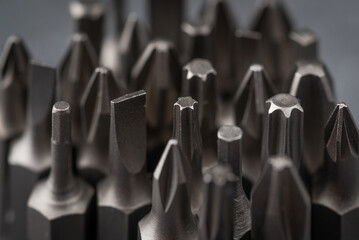 A set of heads for screwdrivers (bits). On a gray background. Close-up. Macro photo, studio shooting.