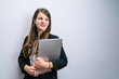 © Jorge - Portrait of young brunette executive girl in American jacket with laptop in her arms. Entrepreneur woman.