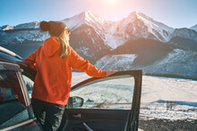 Woman Traveling Exploring, Enjoying The View Of The Mountains, Landscape, Lifestyle Concept Winter Vacation Outdoors. Female Standing Near The Car In Sunny Day, Travel In The Mountains, Freedom