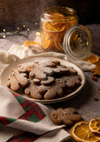 Fototapeta Niebo - Christmas gingerbread cookies sprinkled with powdered sugar with dried oranges laying around