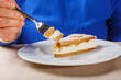 Fetta di torta con pasta frolla alle nocciole ripiena di ricotta, pere e zucchero e guarnita con zucchero a velo servita come dessert mentre viene tagliata da un cliente in un ristorante elegante