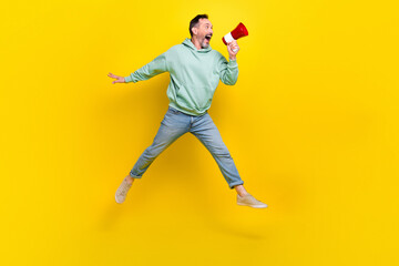 Sticker - Full length photo of excited impressed man wear sweatshirt making toa announcement empty space jumping high isolated yellow color background