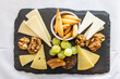 Overhead view on platter of cheese, cracker, nuts and grapes served on cheeseboard