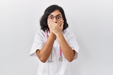 Canvas Print - Young hispanic doctor woman wearing stethoscope over isolated background shocked covering mouth with hands for mistake. secret concept.