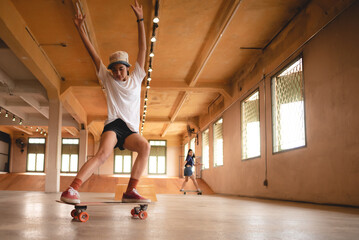 skater woman person playing skateboard in sport gym, young Asian woman are happy and fun with skateboarding lifestyle in city, teenage hipster female trendy fashion