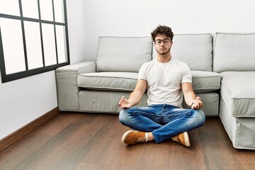 Canvas Print - Young hispanic man doing yoga exercise at home