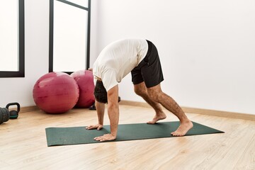 Wall Mural - Young hispanic man stretching at sport center