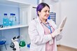 Young beautiful plus size woman scientist smiling confident wearing gloves at laboratory