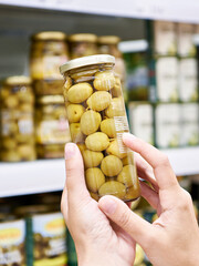 Wall Mural - Canned olives in hands buyer in shop