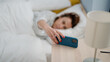 © Krakenimages.com - Middle age hispanic woman turning off smartphone alarm lying on bed at bedroom