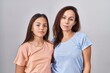 © Krakenimages.com - Young mother and daughter standing over white background relaxed with serious expression on face. simple and natural looking at the camera.