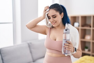 Poster - Young caucasian woman smiling confident holding water using towel at home