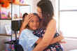 © Caia Image - Portrait affectionate mother hugging disabled daughter at home