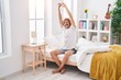 © Krakenimages.com - Young blond man waking up stretching arms at bedroom