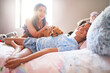 © Caia Image - Portrait happy disabled girl laying on bed with dog and mother