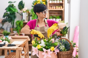 Canvas Print - Middle age chinese woman florist cutting plants at flower shop