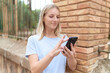 © Krakenimages.com - Young blonde woman smiling confident using smartphone at street