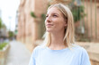 © Krakenimages.com - Young blonde woman smiling confident looking to the sky at street