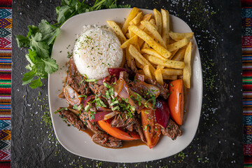 Lomo saltado, a traditional Peruvian stir fry that combines marinated strips of sirloin with onions, tomatoes, french fries and rice.