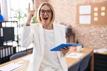 Sticker - Young caucasian woman working at the office wearing glasses pointing finger up with successful idea. exited and happy. number one.