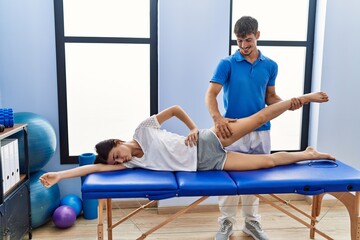 Wall Mural - Man and woman wearing physiotherpy uniform having rehab session at clinic