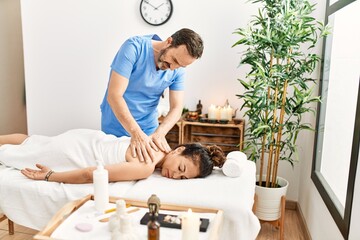 Wall Mural - Middle age man and woman wearing therapist uniform having back massage session at beauty center