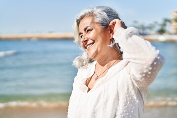 Wall Mural - Middle age woman smiling confident standing at seaside