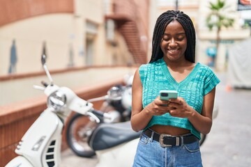 Canvas Print - African american woman smiling confident using smartphone at street