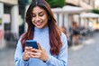 © Krakenimages.com - Young hispanic woman smiling confident using smartphone at street