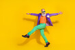 © deagreez - Full length photo of cheerful excited guy dressed violet velvet jacket hands sides walking disco isolated yellow color background