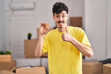 Canvas Print - Hispanic man holding bitcoin at new home skeptic and nervous, frowning upset because of problem. negative person.