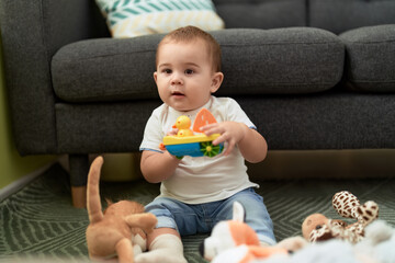 Sticker - Adorable toddler playing with toys sitting on floor at home