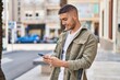 © Krakenimages.com - Young hispanic man smiling confident using smartphone at street