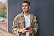 © Krakenimages.com - Young hispanic man smiling confident using smartphone at street