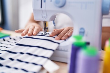 Sticker - Young beautiful hispanic woman tailor using sewing machine at clothing factory