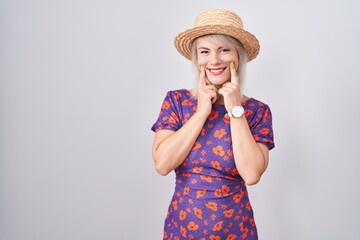 Sticker - Young caucasian woman wearing flowers dress and summer hat smiling with open mouth, fingers pointing and forcing cheerful smile