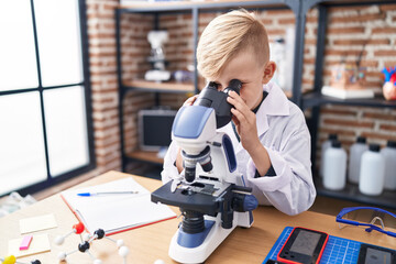 Poster - Adorable toddler student using microscope standing at classroom