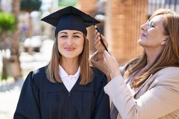 Poster - Mother and daughter celebrating graduation holding tassel at university