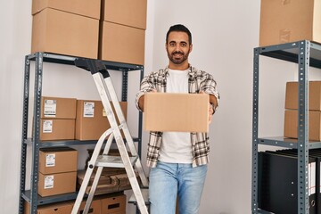 Canvas Print - Young hispanic man ecommerce business worker holding package standing at office