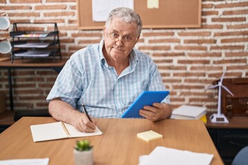 Poster - Middle age grey-haired man business worker using touchpad writing on notebook at office