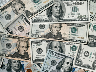 A green background of hundred dollars us scattered on the table. Franklin portrait on a green federal reserve note