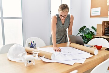 Sticker - Young caucasian woman writing on architect plan working at architecture studio