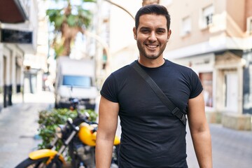 Wall Mural - Young hispanic man smiling confident standing at street